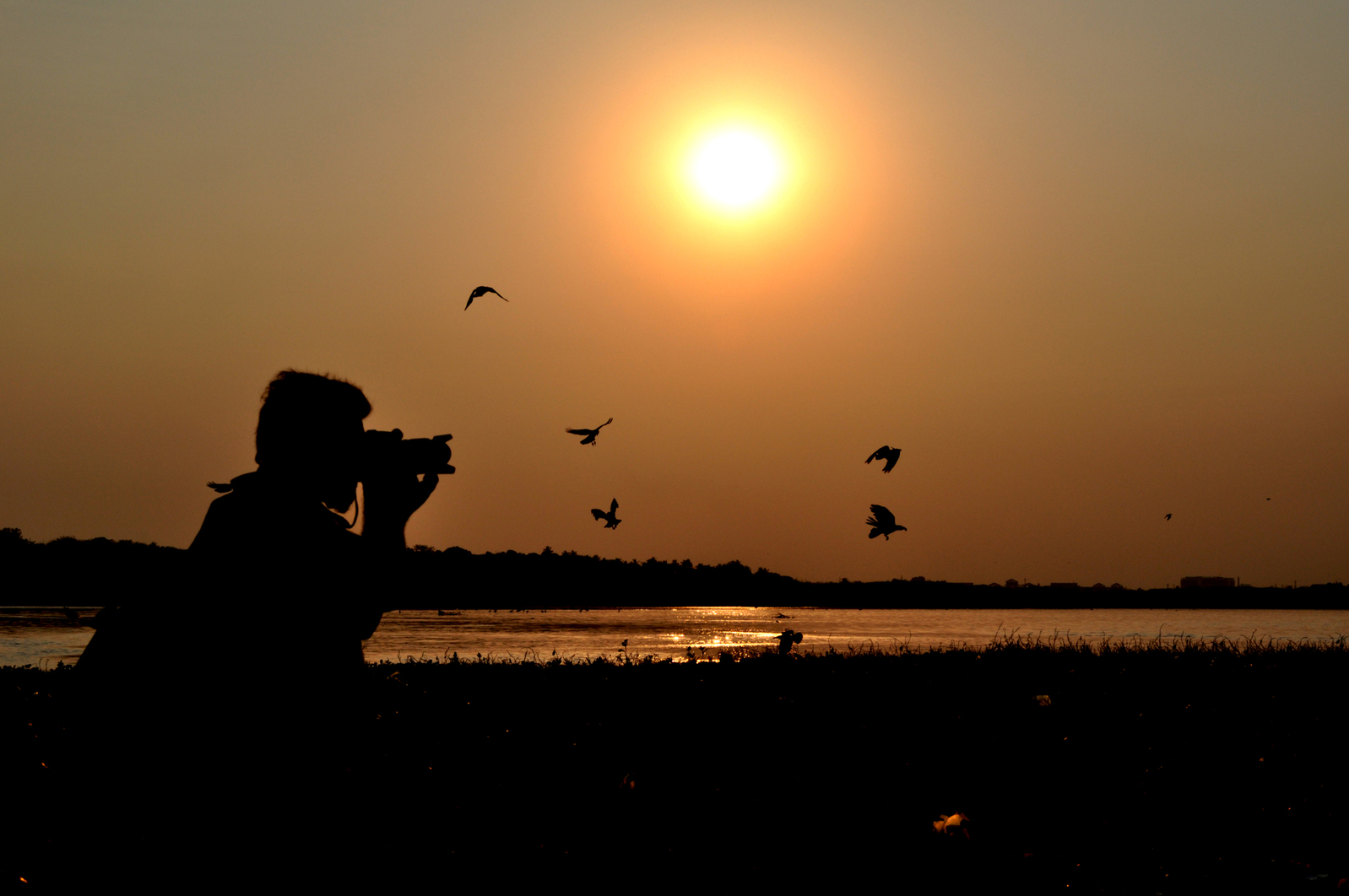 Photographer silhouetted at sunset