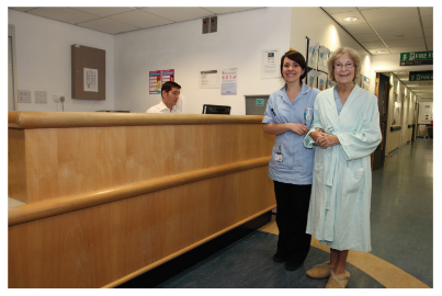 A clinician and patient standing by a reception desk